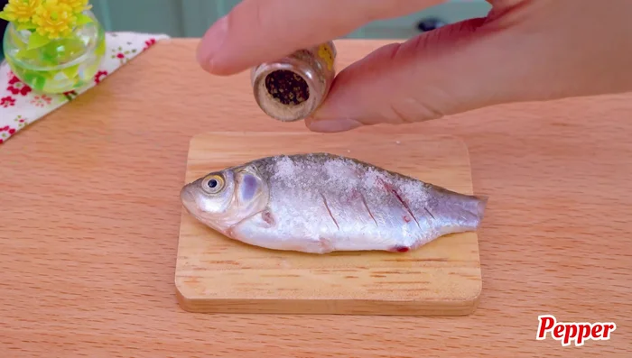 Season the fish with salt, pepper, and turmeric powder.
