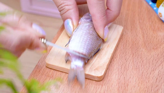Prepare the fish and crab: scale and slice the fish.