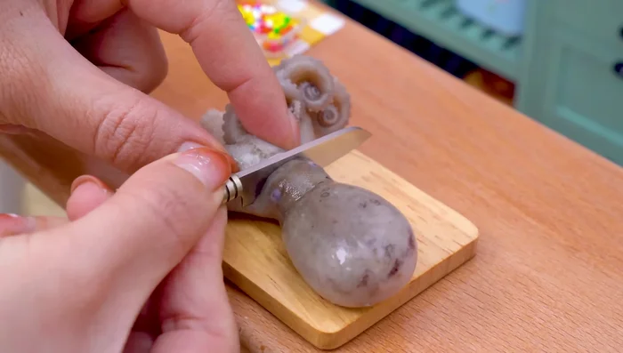 Slice the octopus. Take it out. Now we will slice the octopus head. Then chop its tentacles and place them on a plate.