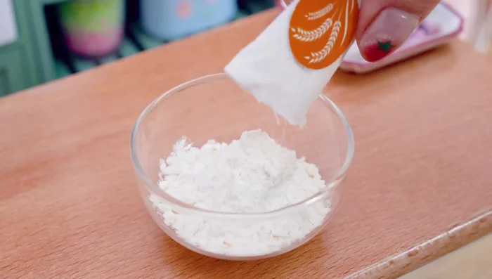 Prepare the batter. Pour the flour into the bowl. Add turmeric powder, chili powder, water. Mix well.