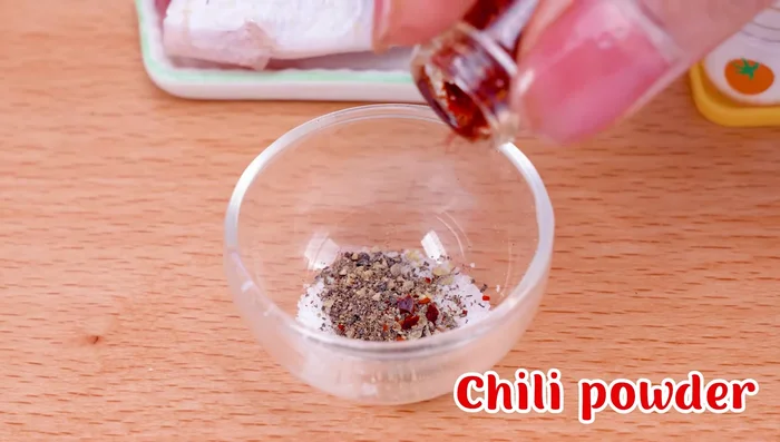 Season the fish with salt, black pepper, chili powder, ketchup, lemon, and cooking oil.