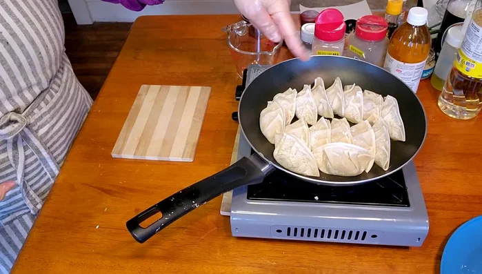 Heat oil in a pan over medium heat. Place the gyoza in the pan, ensuring they don't overlap.