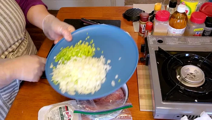 Finely slice the Chinese cabbage and big onion. A food processor can be used, but manual slicing is recommended for better control and texture.