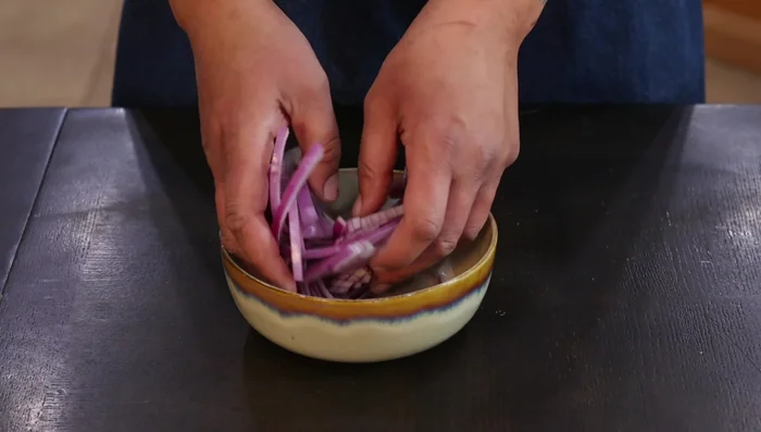 Slice purple onion thinly and pickle it in rice wine vinegar for at least 20-30 minutes (or overnight). (104.64)