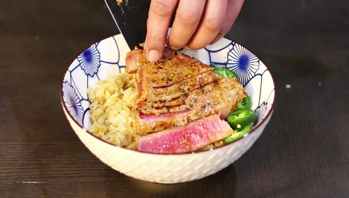 Assemble the bowl: Layer rice, tuna, pickled onions, jalapenos, cilantro, chipotle sauce, and cucumbers. Garnish with furikake. (418.08)