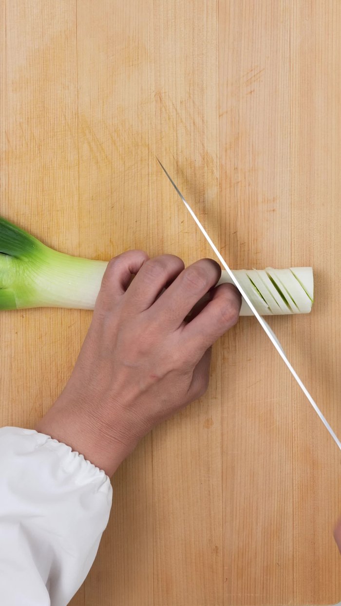 Mince the green onions. Cut halfway through with a kitchen knife, being careful not to cut it off completely. Turn it upside down and make the same cuts. This is called a snake belly cut in Japan.
