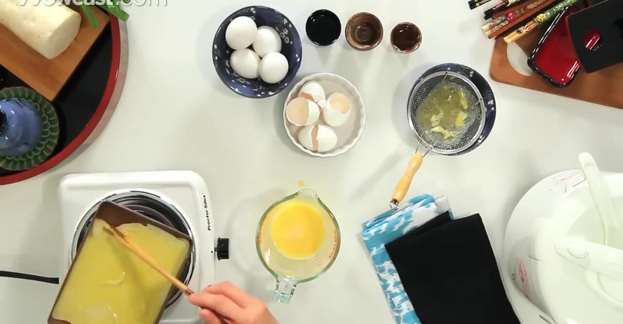 Rolling the partially cooked egg layer