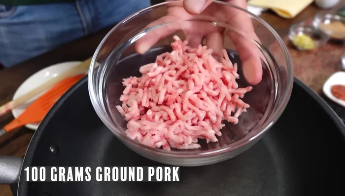 Make Nikumiso (Okinawan pork miso): Stir-fry ground pork in a frying pan until excess fat renders. Add sugar, miso, and minced ginger. Stir-fry until combined. Add sake and cook until thickened. Set aside to cool.