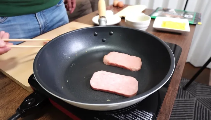 Cook spam: Fry spam slices until lightly crispy on both sides.
