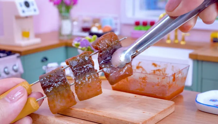Put the eel mixture on a stick and grill it. Spread some sauce.