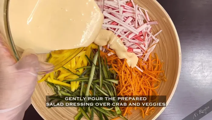 Pour the prepared salad dressing over the crab sticks and vegetables.