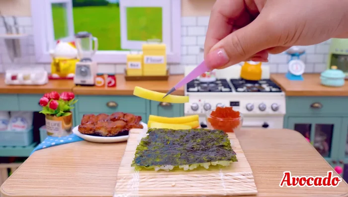 Add avocado, crab stick, and salmon egg to the rice.
