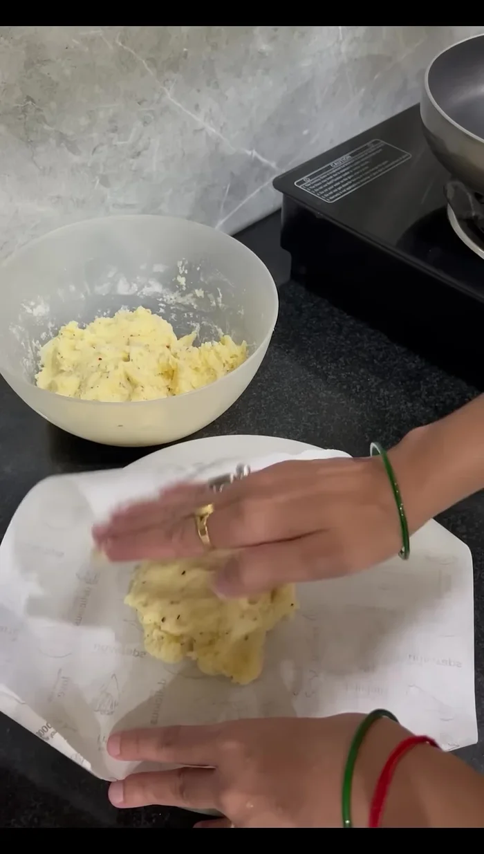 Lightly grease butter paper or parchment paper, place on a surface, and then place the dough on top of the paper. Place another sheet of butter paper/parchment paper on top of the dough. Roll out the dough using a rolling pin.