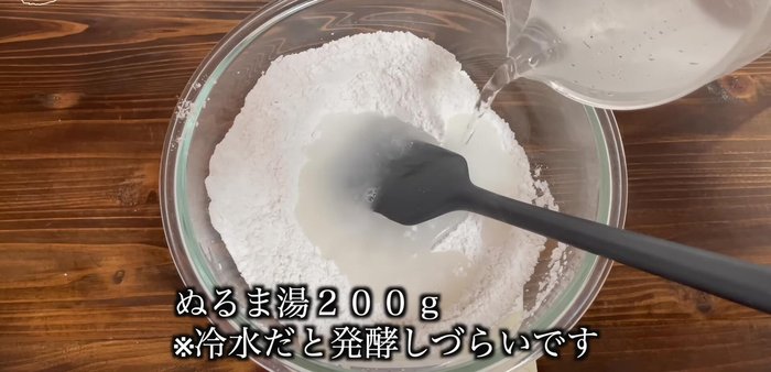 Add 200g of warm water and 12g of oil. Mix thoroughly until a sticky dough forms.