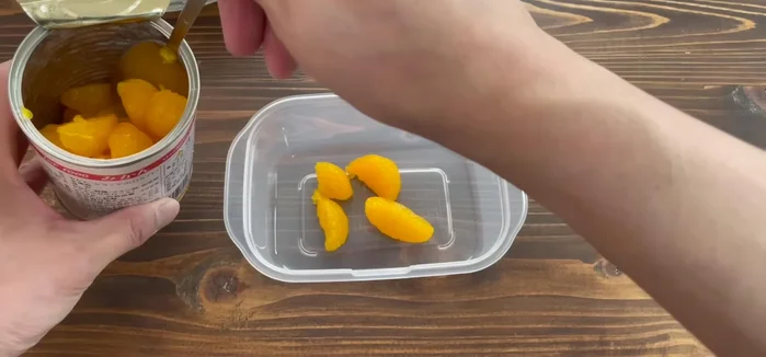 Layer your chosen fruits (e.g., Mika fruit, canned mixed fruit, or none) in the Tupperware.