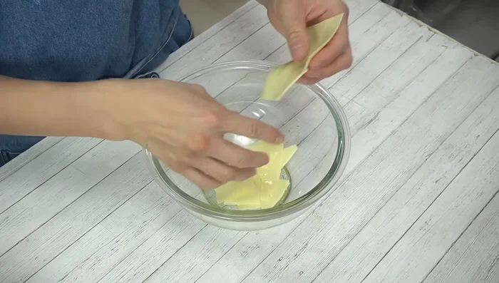 Tear sliced cheese into pieces and place in a heat-resistant bowl. Add milk, cover with plastic wrap, and microwave at 600W for 1 minute 30 seconds. Mix well to melt cheese completely.