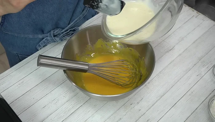 Add cooled cheese mixture to egg yolks and mix well. Add flour and mix thoroughly.