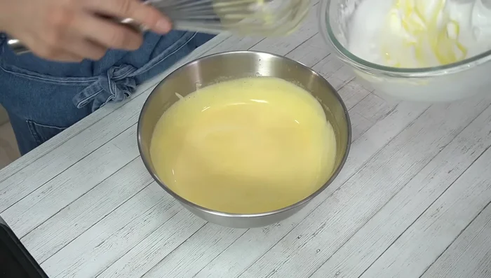 Gently fold 1 scoop of meringue into the egg yolk mixture, then add the rest gently, being careful not to deflate the meringue.
