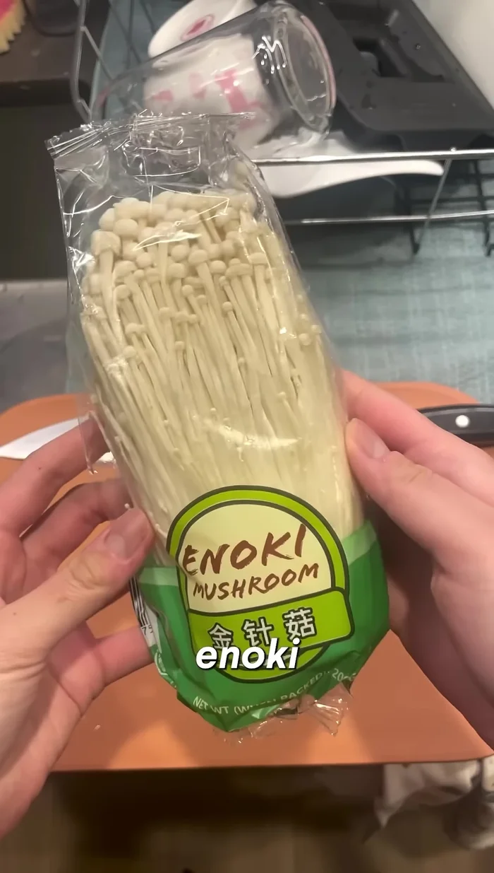 Cut off the bottom end of the enoki mushrooms and separate the strands.