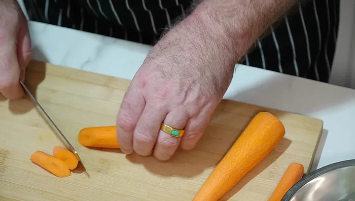 Prepare vegetables: Cut carrots on an angle, cube onions, and cube potatoes.