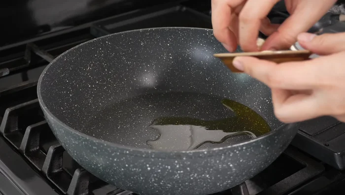 Heat vegetable oil in a pan. Add minced garlic and cook slowly over low heat until fragrant.