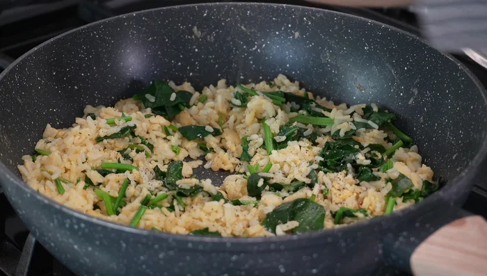 Add chopped spinach and stir-fry until wilted. Season with salt and pepper.