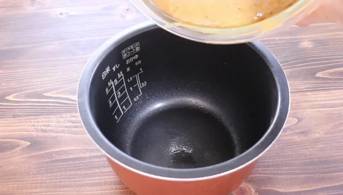 Pour the batter into the prepared rice cooker bowl.