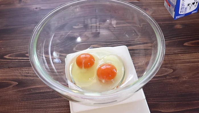 In a bowl, whisk together 2 eggs and 200g of milk.