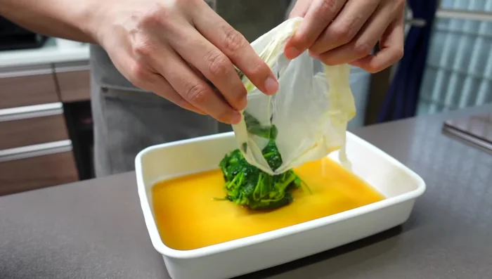 Add drained molokhia and yam to the seasoning. Mix well. For a crispier texture, leave as is. For a stickier texture, finely chop the molokhia and yam before adding.