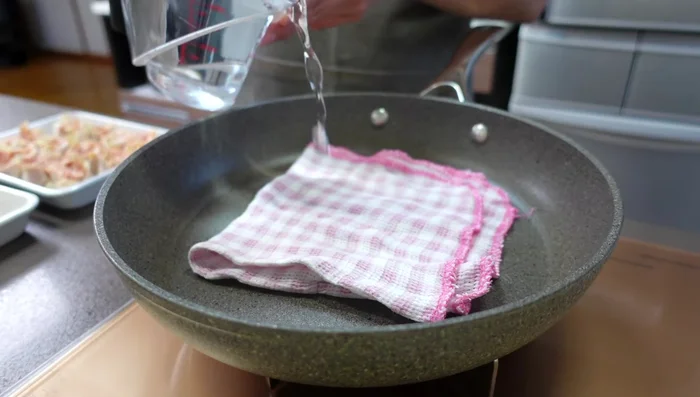 Place the shumai in a frying pan, add about 1cm of water, and bring to a boil. Cover with a heat-resistant plate and container, then steam over low heat for 10 minutes.