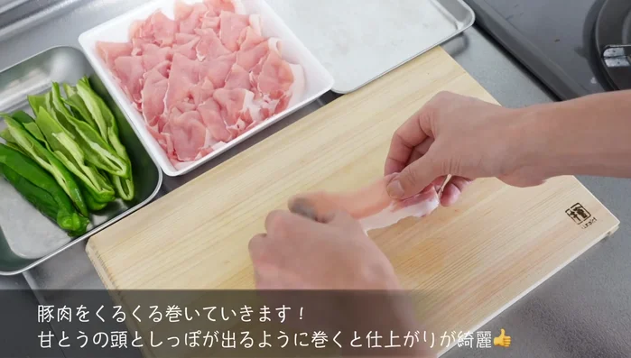 Prepare the pork loin by cutting it into thin slices. Wrap each slice of pork around a chili pepper.
