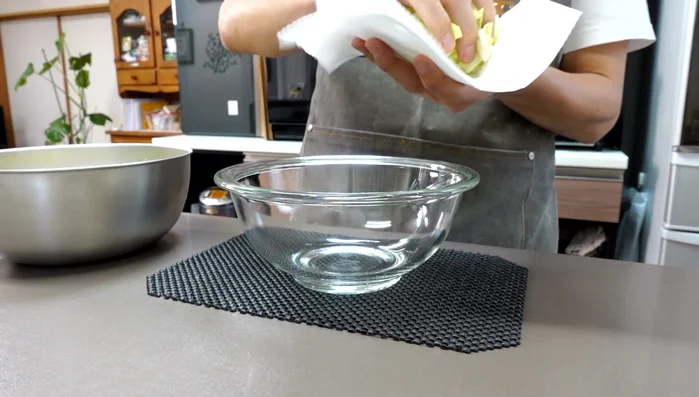After 15 minutes, squeeze out excess moisture from the salted cabbage using paper towels.