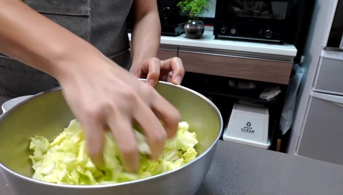 Transfer the cabbage to a bowl, sprinkle with salt, and rub it. Let it sit for about 15 minutes.