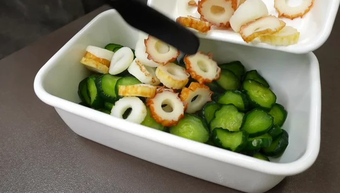 Add the cucumbers and chili peppers to a storage container. Pour the hot pirika sauce over them.
