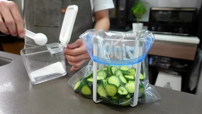 Add salt to the bag and rub it into the cucumbers to draw out moisture. Seal the bag, removing as much air as possible.