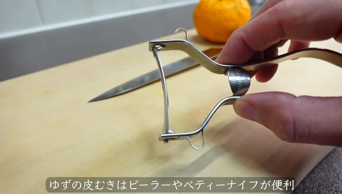 Peel the yuzu using a peeler or paring knife (a paring knife is recommended for better control). Remove the white pith from the inside of the peel as it's bitter.