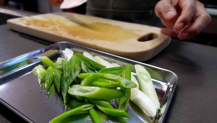 Add the green onions to the pot with the pork and tofu broth. (Optional: add shirataki noodles or mushrooms)