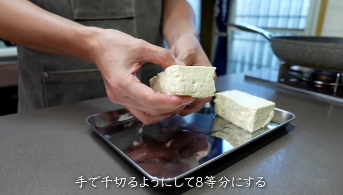 Tear the parboiled tofu into 8 equal parts by hand. This uneven texture helps the flavor soak in better than cutting with a knife.