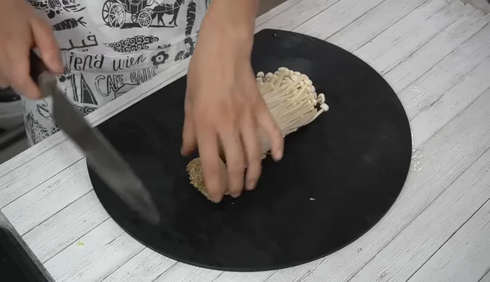 Cut off the bottom of the enoki mushrooms and loosen them with your hands.