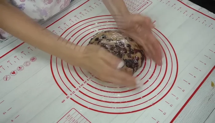 Shape the stollen: On a lightly floured surface, shape the dough into a rectangle. Fold it over, then fold again, leaving 1/3 of the dough uncovered. Shape it into an oblong shape.