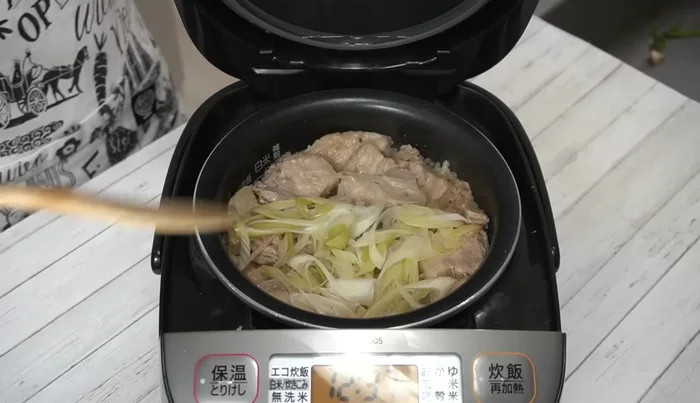 Once cooked, remove the green parts of the spring onions and gently mix the rice and pork belly together.