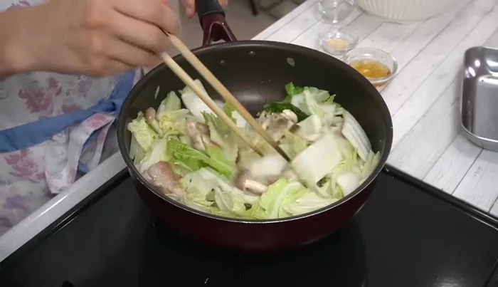 Add grated garlic, chicken stock powder, white stock, and water. Bring to a boil, then reduce heat, cover, and simmer for 15 minutes.