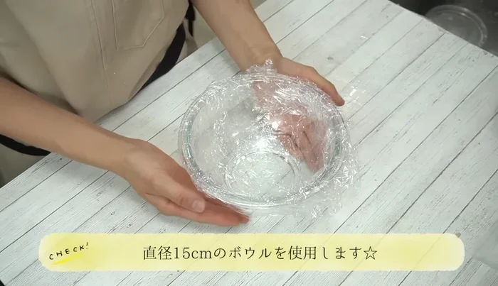Assemble the cake: Place the 18cm sponge on a bowl lined with plastic wrap. Pipe a layer of stiff cream, add strawberries, and repeat with another layer of cream and the 10cm sponge. Top with more cream and the 15cm sponge.