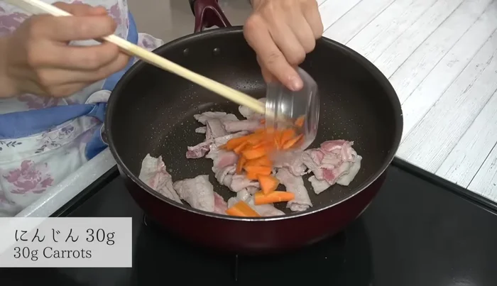 Add carrots and the cabbage core, stir-frying until the oil coats the vegetables.