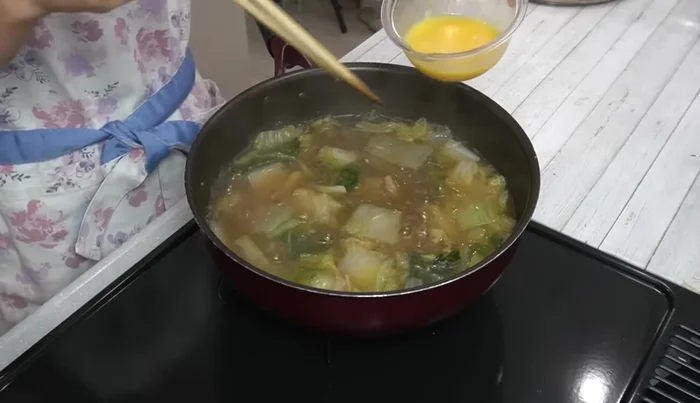 Return to heat for about a minute. Add beaten eggs in small circular motions using chopsticks. Do not stir until the eggs are set.