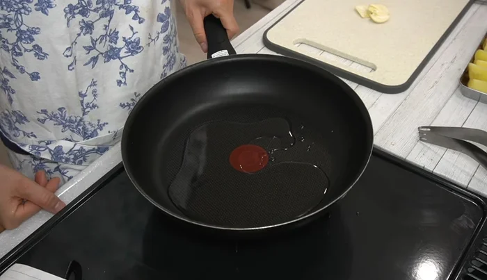 Heat 2 tablespoons of oil in a frying pan over medium heat. Add garlic, cut-side down, and cook for 1 minute.