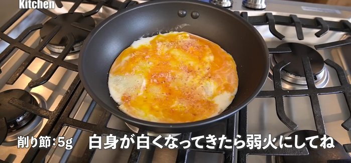 Sprinkle bonito flakes and spring onions over the eggs while they are still half-cooked.