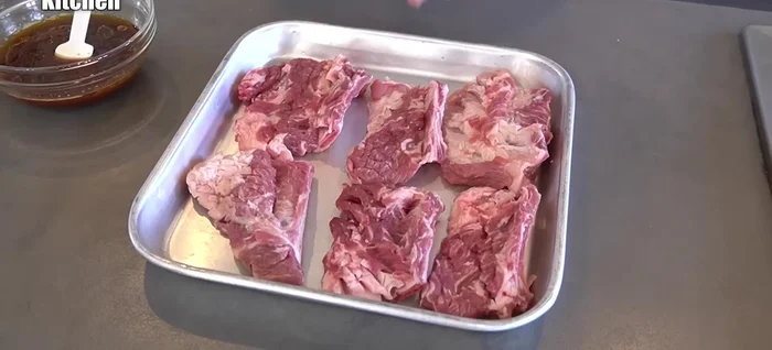 Generously rub the sauce into the ribs, ensuring it penetrates the cuts.