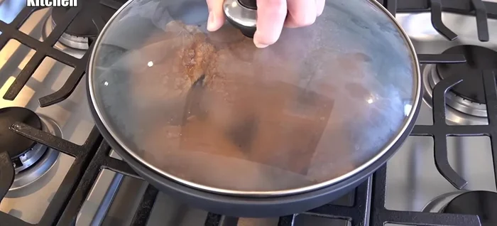 Add sake to the pan, reduce heat, and steam the ribs to cook them thoroughly inside. Low heat is crucial to prevent burning and retain moisture.