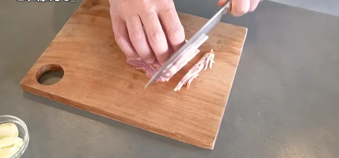 Cut the bacon into thin strips.